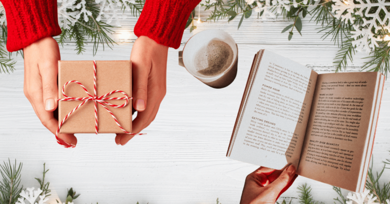 Hands holding a gift box and reading a book surrounded by holiday decor