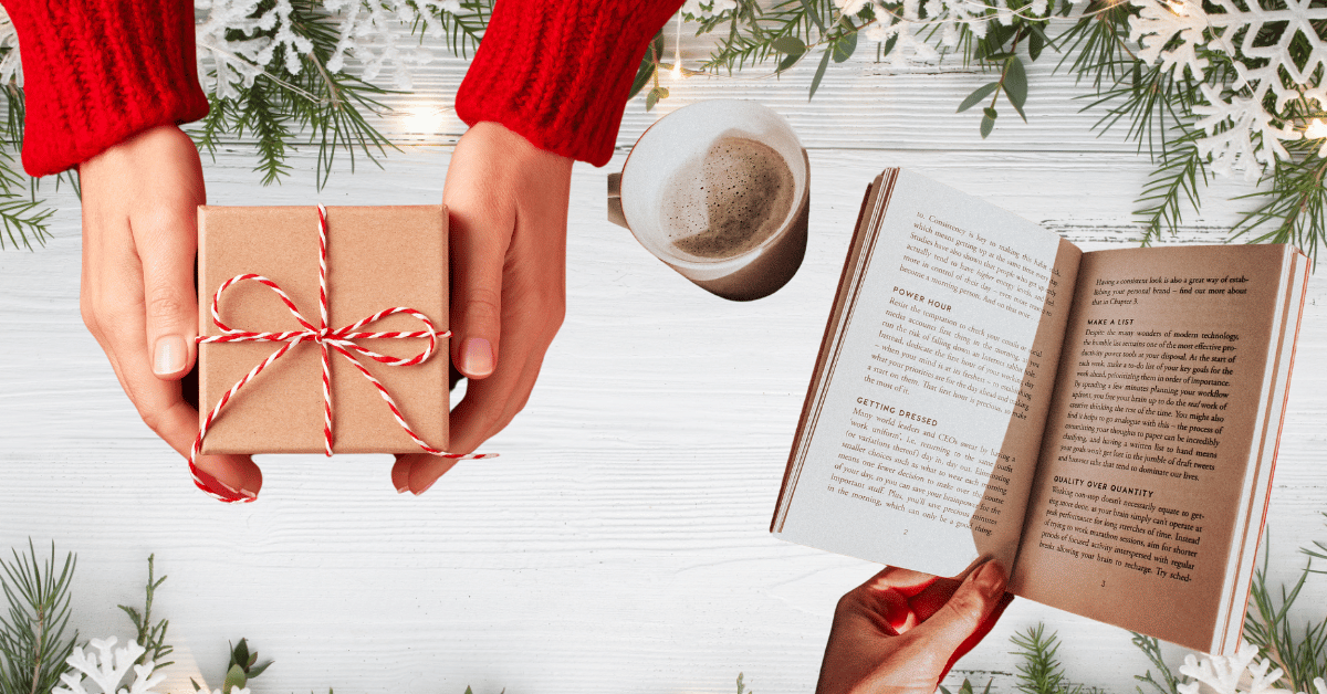 Hands holding a gift box and reading a book surrounded by holiday decor