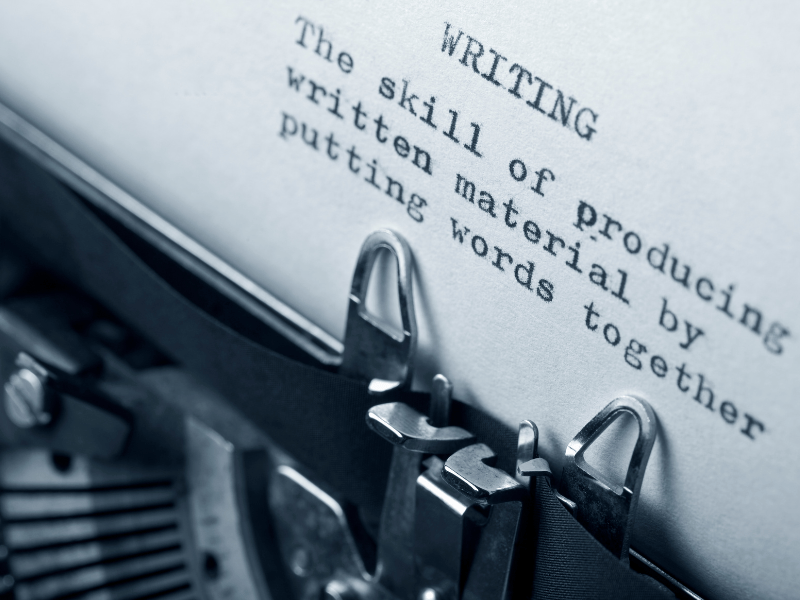 A close-up of a typewriter with the definition of writing, focusing on the meaning of storytelling.