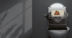 A vintage typewriter sitting on a toilet with a sheet of paper showing a cartoon poop emoji, symbolizing messy first drafts and the creative process.