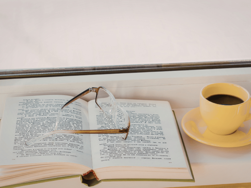 Open notebook with handwritten notes and a cup of coffee, suggesting journaling and thoughtful reflection