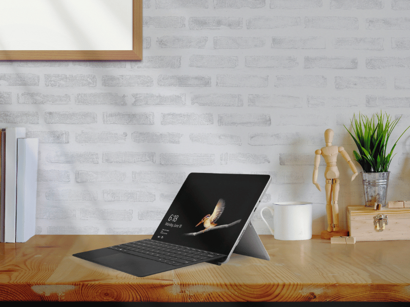 Minimal writing setup with a small laptop on a desk, representing a lightweight and flexible way to write outside a traditional workspace.