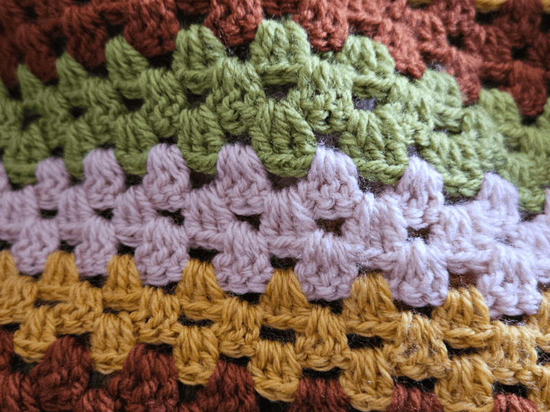 colorful crochet stitches closeup in brown green lavender and yellow, a slow creative process during burnout recovery